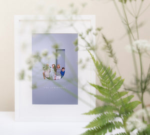 lifestyle image of family in a capital letter design in a white wood picture frame