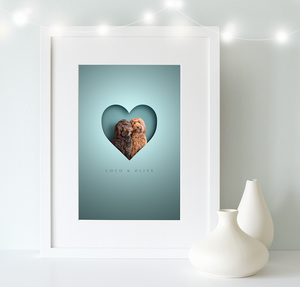White, wooden framed picture of 2 shaggy cockapoo dogs in a cut out heart shape and their names written underneath