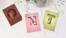 Load image into Gallery viewer, set of 3 colourful 3d-effect letter pictures in white picture mounts. 