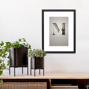 dog portrait of spaniel in a 3D-effect serif letter with name underneath hanging in a black frame on a wall