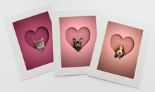 Load image into Gallery viewer, set of 3 pictures in shades of pinks and in white photo mounts. Each one is a head shot of a tabby cat, black frenchie and sad looking Beagle sitting inside a heart shape looking out at the viewer